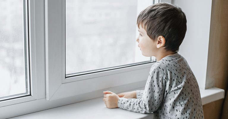 Child standing next to UPVC Awning Windows in bedroom at Energy Efficient Windows Australia