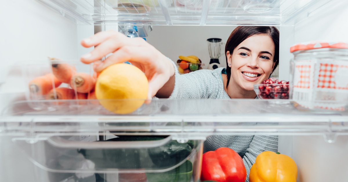 A woman taking a fruits and vegetables on a refrigerator at Energy Efficient Windows Australia